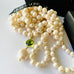Leoni & Vonk long pearl necklace with a green gemstone drop and with a black box and Leoni & Vonk ribbon
