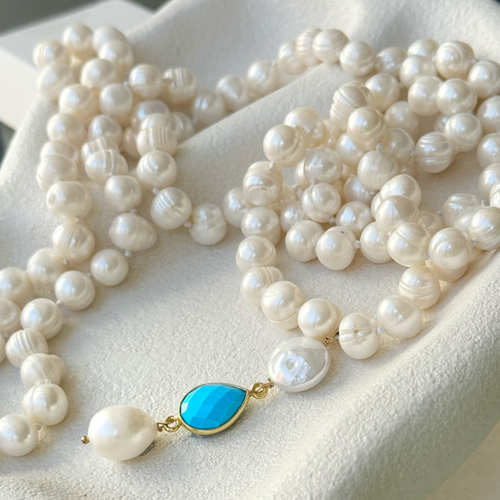 Leoni & Vonk long pearl and turquoise necklace on a white textured background