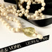 Leoni & Vonk long pearl and citrine birthstone necklaceon a white surface with Leoni & Vonk ribbon and a box