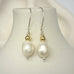 Leoni & Vonk pearl earrings hanging on a white vase