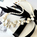 Leoni and Vonk pearl necklace on a white background and with Leoni  & Vonk ribbon