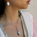 Cropped image of a girl looking to the side and wearing Leoni & Vonk jewellery