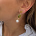 Image of a girls ear wearing Leoni & Vonk August peridot and pearl drop earrings