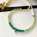 Leoni & Vonk peridot, pearl and green onyx neckalce on a white background and with Leoni & Vonk ribbon