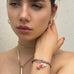 DArk haired girl wearing Leoni & Vonk leather jewellery. She has he hand up behind her ear.