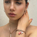 DArk haired model wearing Leoni & Vonk jewellery. She has her hand behind her ear.
