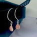 Leoni & Vonk pink opal silver earrings on a black box