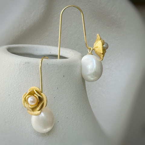 Leoni & Vonk gold flower and pearl earrings on a white vase