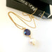 Leoni & Vonk sapphire and pearl necklace on a white background with Leoni & Vonk ribbon and box