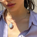 Cropped image of a dark haired girl wearing Leoni & Vonk jewellery and a lilac shirt
