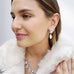 Dark haired girl wearing Leoni & vonk vintage crystal and pearl earrings and vintage crystal necklace and a cream fur coat.