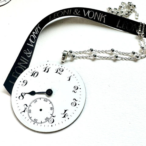 Leoni & Vonk vintage watch face necklace on a white background and with Leoni & Vonk ribbon