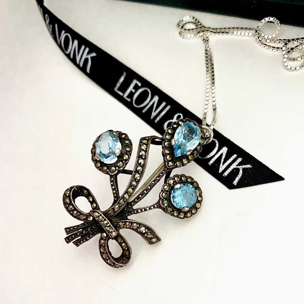 Leoni & Vonk vintage marcasite and pale blue stone brroch/neckalce on a white background with Leoni & Vonk ribbon