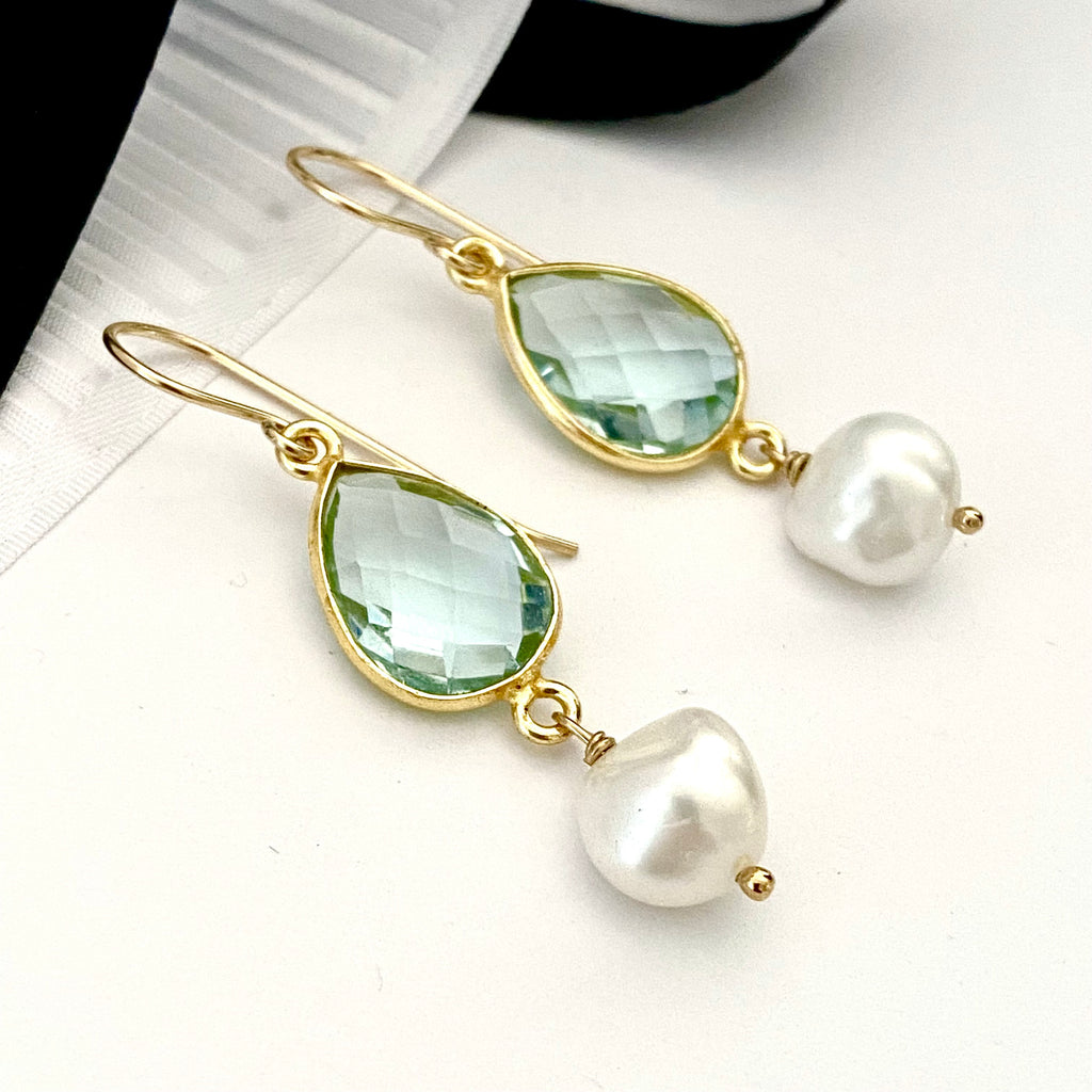 Leoni & Vonk March aquamarine birthstone and white pearl earrings on a white background with black and white ribbon