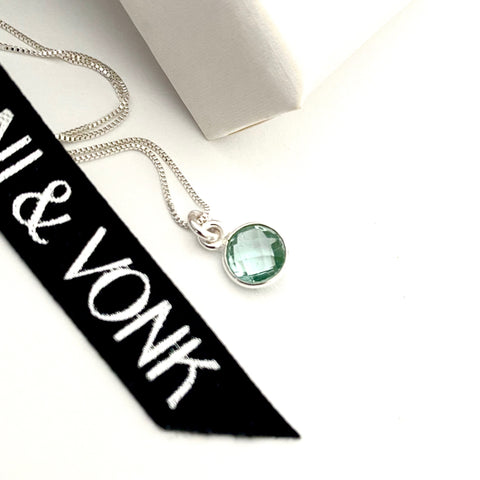 Leoni & Von aquamarine silver dot necklace photographed against a white background and Leoni & Vonk ribbon.