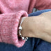 Model wearing pink jumper and Leoni & Vonk sterling silver ball bracelet