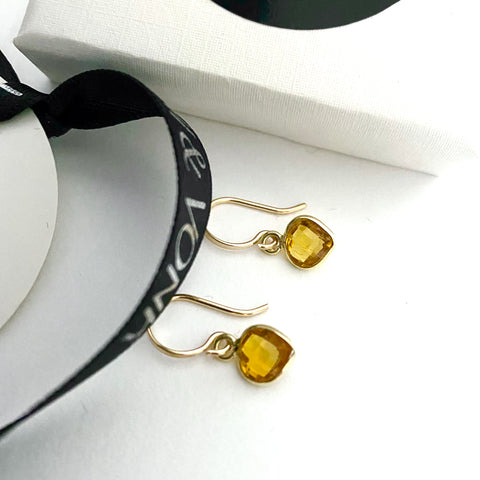 Leoni & Vonk citrine heart earrings photographed near a white box and Leoni & Vonk ribbon