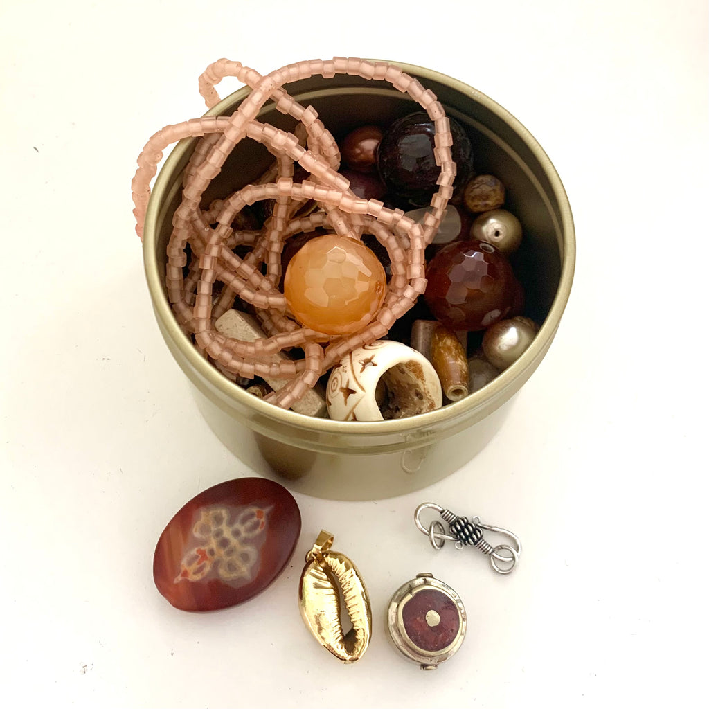 Leoni & Vonk earth bead tin with a variety of beads in different shapes and sizes.