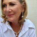Blonde woman wearing Leoni & Vonk jewellery and a white shirt. She is looking to the left of the frame