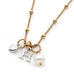 Leoni & Vonk gold chain necklace with a silver heart, H initial and white pearl all on a white background. 
