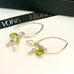 Leoni & Vonk sterling silver, pearl and peridot charm earrings on a white background with leoni & Vonk ribbon