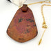 Back of Leoni & Vonk Kubasek copper pendant neckalce with a white box and Leoni & Vonk ribbon