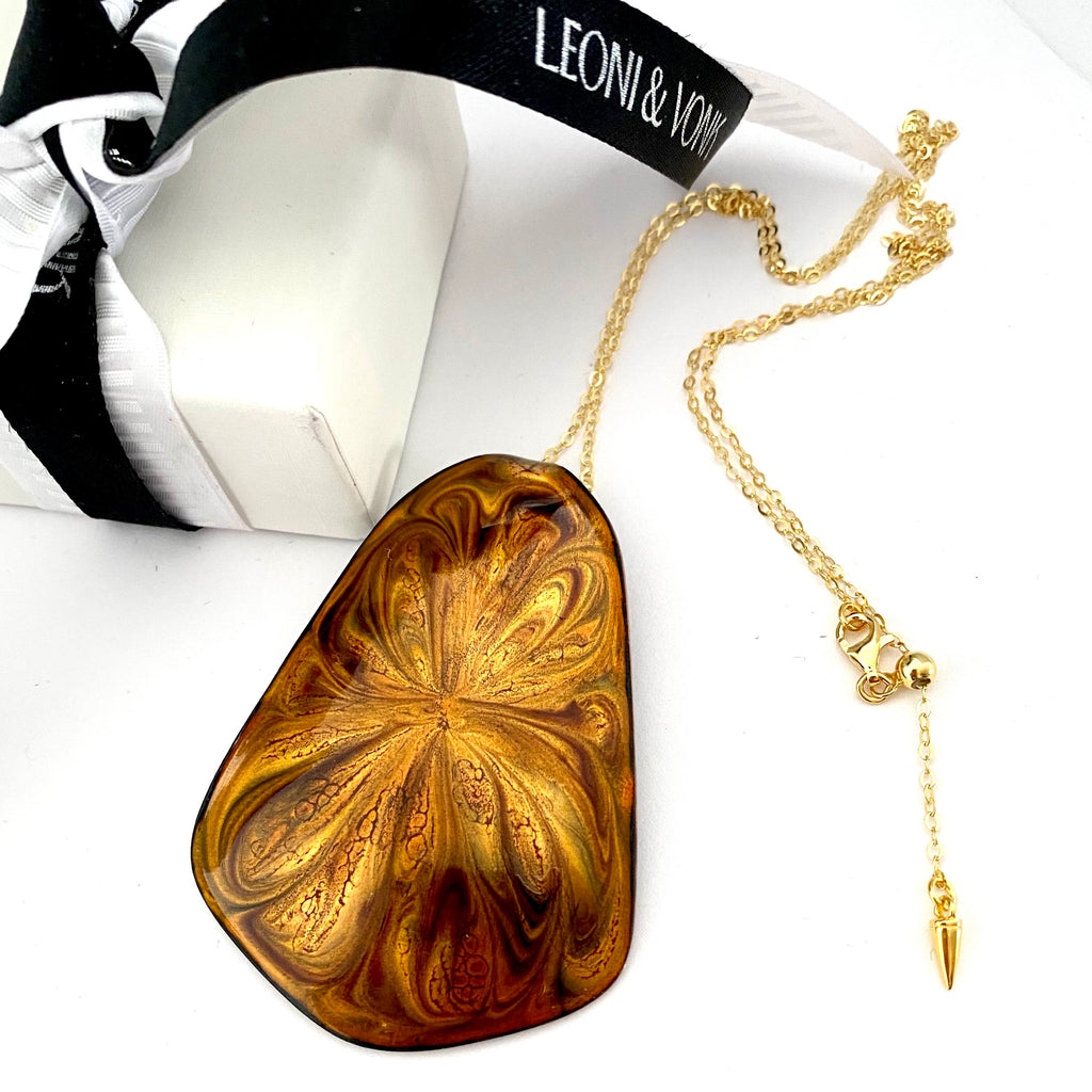 Leoni & Vonk Kubasek copper pendant neckalce with a white box and Leoni & Vonk ribbon