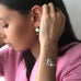 Model wearing Leoni & Vonk earl friendship bracelets, keshi pearl earrings and a pink Zara jacket