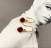 Leoni & Vonk ruby and gold heart earrings photographed on a magazine page