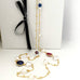 Leoni & Vonk ruby, sapphire, pearl gold necklace photogrpahed near a white box and ribbon