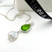 Leoni & Vonk peridot and pearl August birthstone necklace photographed near Leoni & Vonk ribbon and a white box