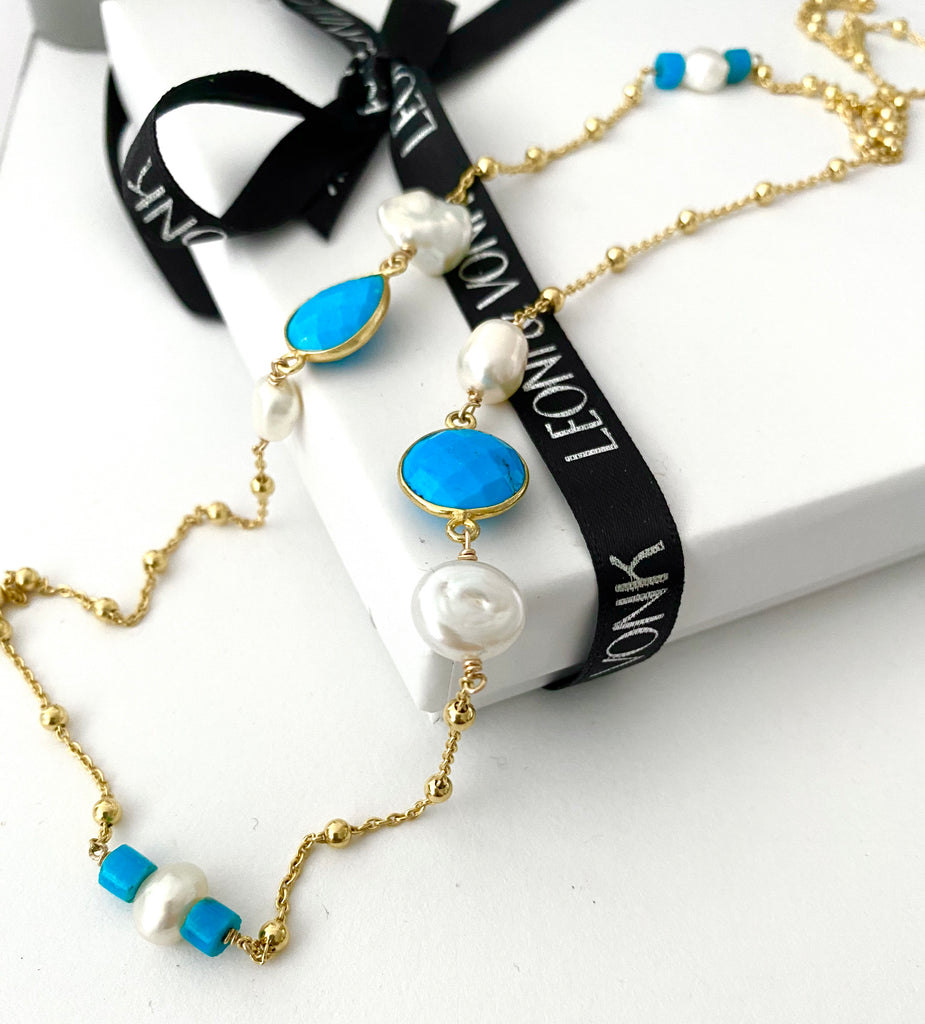Leoni & Vonk turquoise, pearl adn gold necklace photographed on a Leoni & Vonk box