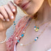 Model wearing Leoni & Vonk turquoise, pearl and gold necklace  and gold compass necklace