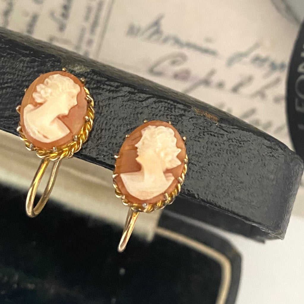 Leoni & Vonk vintage gold plated cameo earrings with screw backs on a vintage box and a vintage postcard