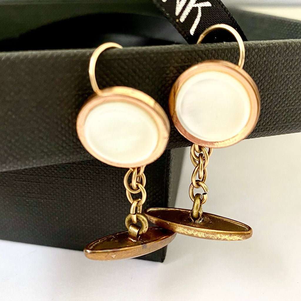 Leoni and Vonk-mother of pearl and gilt cufflink earrings on a black box .